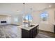 Modern kitchen island with a sink, seating, stainless steel appliances and backyard views at 747 Sunflower Dr, Brighton, CO 80601