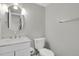 This bathroom features a white marble vanity, toilet, and a large round mirror at 857 S Van Gordon Ct # H101, Lakewood, CO 80228