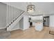 This room features a staircase, lighting fixture, wood floors, and view of the kitchen at 857 S Van Gordon Ct # H101, Lakewood, CO 80228