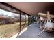 Relax on the covered patio with a swing, surrounded by a grassy yard and privacy fence at 1288 S Drexel Way, Lakewood, CO 80232