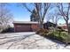Charming brick and wood home with a well-maintained front yard and a driveway leading to the garage at 1288 S Drexel Way, Lakewood, CO 80232