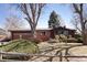 Charming one-story home featuring a well-manicured lawn, a brick facade, and an attached garage at 1288 S Drexel Way, Lakewood, CO 80232