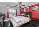 Comfortable bedroom with dark hardwood floors and bright red accent wall at 9626 Whitecliff Pl, Highlands Ranch, CO 80129