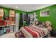 Bright green bedroom featuring a bed covered in plush toys and storage boxes at 9626 Whitecliff Pl, Highlands Ranch, CO 80129