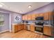 Galley kitchen with natural wood cabinets, stainless steel appliances, and hardwood floors at 9626 Whitecliff Pl, Highlands Ranch, CO 80129