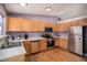 Bright galley kitchen featuring stainless steel appliances and natural wood cabinetry at 9626 Whitecliff Pl, Highlands Ranch, CO 80129
