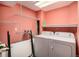 Laundry room with washer, dryer, and shelving for storage, and coral colored walls at 9626 Whitecliff Pl, Highlands Ranch, CO 80129