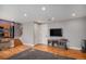 Cozy living room with hardwood floors, fireplace, and TV with easy access to the kitchen and upstairs at 9626 Whitecliff Pl, Highlands Ranch, CO 80129