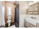 Well-lit bathroom featuring a charming sink, white wainscoting, and a patterned shower curtain at 28505 County Road 5, Elizabeth, CO 80107