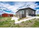 Exterior showcasing a charming home with well-maintained lawn, complemented by a spacious patio and lush greenery at 28505 County Road 5, Elizabeth, CO 80107