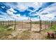 A sturdy horse corral set against a vast, open landscape and a bright blue sky with fluffy white clouds at 28505 County Road 5, Elizabeth, CO 80107