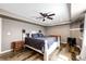 Finished main bedroom with wood-look floors, a ceiling fan, and a dark blue comforter on a white framed bed at 28505 County Road 5, Elizabeth, CO 80107