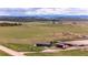 Expansive mountain view with rolling hills, farm house, and grazing land under a serene sky with wispy clouds at 28505 County Road 5, Elizabeth, CO 80107
