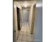Hallway with tiled floors, mirrored closet, and neutral paint, providing a clean transition between rooms at 8826 E Florida Ave # 204, Denver, CO 80247