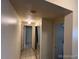 Hallway with tiled floors, mirrored closet, and neutral paint, providing a clean transition between rooms at 8826 E Florida Ave # 204, Denver, CO 80247