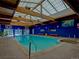 Indoor pool with large skylight, wood beams, hot tub, and blue accent wall, creating a refreshing atmosphere at 8826 E Florida Ave # 204, Denver, CO 80247