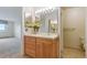 Bathroom vanity featuring wood cabinets, white sink, and decorative floral arrangement on a neutral color scheme at 14050 E Linvale Pl # 601, Aurora, CO 80014