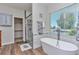 Modern bathroom featuring a soaking tub, walk-in shower, and a large window overlooking the outdoors at 29852 E 163Rd Pl, Brighton, CO 80603