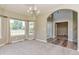 Inviting living room featuring a chandelier, large windows, and an archway leading to the entrance at 29852 E 163Rd Pl, Brighton, CO 80603