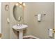 Stylish powder room features a pedestal sink, oval mirror, and updated fixtures at 29852 E 163Rd Pl, Brighton, CO 80603