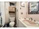 Functional bathroom featuring a sink, toilet, cabinet, and decorative mirror and wall hangings at 19502 E Buchanan Pl, Aurora, CO 80011
