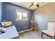 Blue bedroom featuring a window, wood flooring, ceiling fan, and a painting easel at 19502 E Buchanan Pl, Aurora, CO 80011