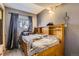 Bedroom with a dark gray accent wall, ceiling fan, window, wood frame bed, and wood flooring at 19502 E Buchanan Pl, Aurora, CO 80011