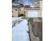 Exterior view of townhouse with snow-covered yard, attached garage, and walkway at 442 S Kalispell Way # C, Aurora, CO 80017