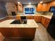 Kitchen island with granite countertop and cooktop at 442 S Kalispell Way # C, Aurora, CO 80017