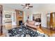 Cozy living room with hardwood floors, brick fireplace, ceiling fan, and vintage furniture at 7996 Bradburn Blvd, Westminster, CO 80030
