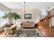 Elegant living room featuring hardwood floors, a decorative rug, staircase, and a large window at 7996 Bradburn Blvd, Westminster, CO 80030