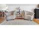 Cozy living room showcases hardwood floors, neutral paint, and 2 comfortable chairs at 7996 Bradburn Blvd, Westminster, CO 80030