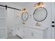 Modern bathroom with double vanity, stylish fixtures, and a sleek sliding barn door at 1175 Oakhurst Dr, Broomfield, CO 80020
