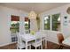 Charming dining area with a white table, bright windows, and backyard access at 1175 Oakhurst Dr, Broomfield, CO 80020