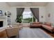 Bright living room with hardwood floors, large window with view, cozy seating, and stylish decor at 1175 Oakhurst Dr, Broomfield, CO 80020