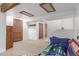 Finished basement with exposed wooden beams and a bed; also includes a closet and a door with a louvered finish at 14093 E Radcliff Cir, Aurora, CO 80015