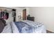 A bedroom with a closet filled with clothes and other items, as well as a bed with blue sheets and a blue plaid blanket at 14093 E Radcliff Cir, Aurora, CO 80015