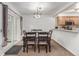 Bright dining room with a stylish chandelier, sliding glass doors, and an adjacent kitchen at 14093 E Radcliff Cir, Aurora, CO 80015