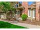 Charming townhome featuring a brick facade, inviting front entrance, and a well-maintained landscaped yard at 14093 E Radcliff Cir, Aurora, CO 80015