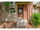Inviting front entryway with a beautiful wooden door, brick accents, and well-maintained landscaping at 14093 E Radcliff Cir, Aurora, CO 80015