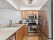 Well-equipped kitchen with stainless steel appliances and light wood cabinets at 14093 E Radcliff Cir, Aurora, CO 80015