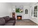 Inviting living room with a cozy fireplace, modern decor, and natural light from the window at 14093 E Radcliff Cir, Aurora, CO 80015