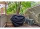 Cozy patio area with privacy fence, shaded by mature trees, and an outdoor grill at 14093 E Radcliff Cir, Aurora, CO 80015