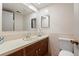 Bathroom featuring vanity with sink, large mirror and toilet in a well-lit space at 2799 S Ingalls Way, Denver, CO 80227