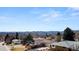 Suburban home featuring brick accents, a well-maintained lawn, and picturesque views of the distant mountains at 2799 S Ingalls Way, Denver, CO 80227
