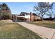 View of the home showing the long driveway, carport, and back sunroom at 2799 S Ingalls Way, Denver, CO 80227