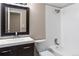 Bathroom features a dark wood vanity with a modern sink and faucet and a shower-tub combo at 4400 S Quebec St # 108L, Denver, CO 80237