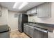 Well-organized kitchen equipped with stainless steel appliances, granite counters, and stylish gray cabinetry at 4400 S Quebec St # 108L, Denver, CO 80237