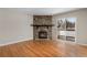 Cozy living room featuring a stone fireplace, hardwood floors, and a sliding door to private balcony at 4400 S Quebec St # 108L, Denver, CO 80237