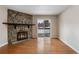 Bright living area with hardwood floors, a stone fireplace, and sliding glass doors leading to outdoor space at 4400 S Quebec St # 108L, Denver, CO 80237